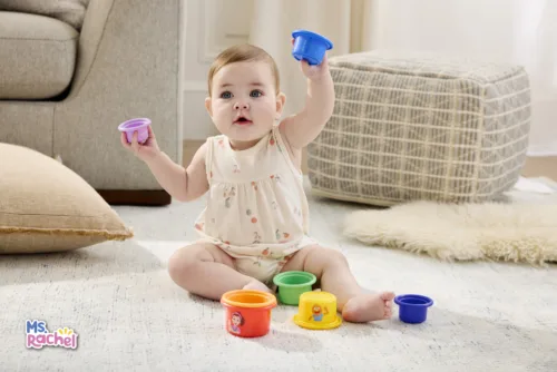 Still lifestyle image of baby playing with rainbow stacking cups for Ms. Rachel Toy Collection by Photographer David Land, represented by Pat Bates & Associates, a leading photo and artist agency in the lifestyle, baby and kids retail sectors.