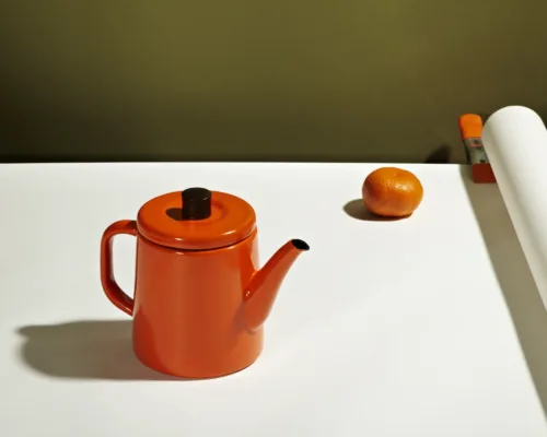 Still life image of orange teapot by photographer Janelle Jones, represented by Pat Bates & Associates, a premier photo and artist agency in the editorial, lifestyle and retail home decor sectors.