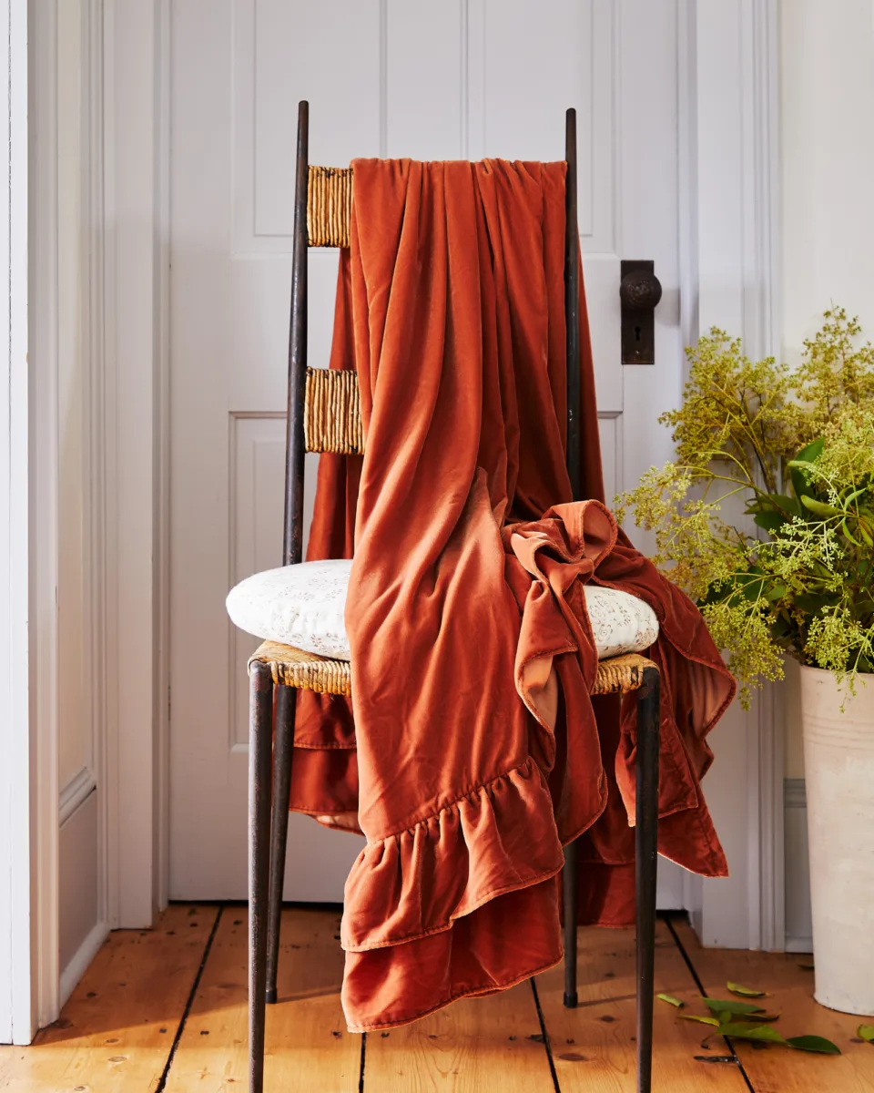 Interior still image of chair with throw blanket for GreenRow with prop styling by John Dittrick, represented by Pat Bates & Associates, a premier photo and artist agency in the retail home brand sector.
