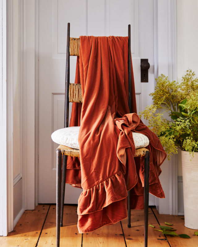 Interior still image of chair with throw blanket for GreenRow with prop styling by John Dittrick, represented by Pat Bates & Associates, a premier photo and artist agency in the retail home brand sector.
