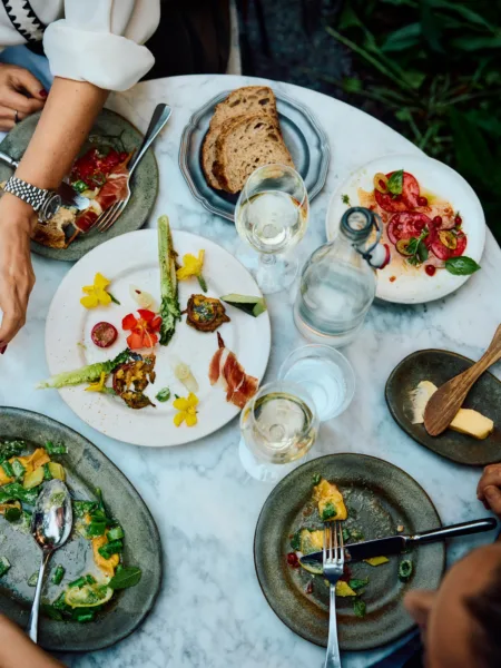 Dining still image of tabletop with people enjoying food for Ett Hem by photographer Lennart Weibull, represented by Pat Bates & Associates, a leading photography agency in the hospitality and retail food and beverage sectors.