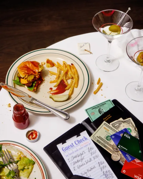 Food and Drink stylist Liberty Fennell sets the scene for the Wall Street Journal editorial on restaurant bill etiquette with a half-eaten hamburger, fries and martini plus the check.