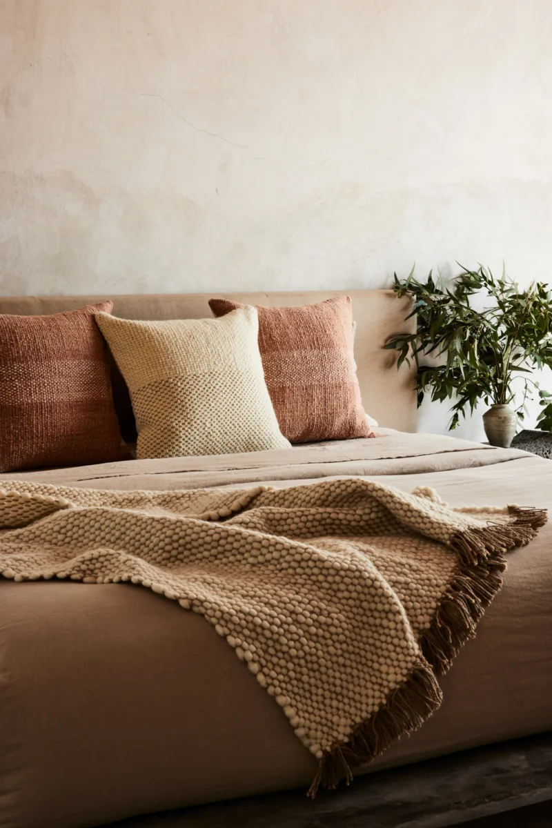 Interior still image of throw blanket on couch for Sien and Co with soft styling by Oliver Cano, represented by Pat Bates & Associates, a premier photo and artist agency in the interiors and retail home brand sectors.