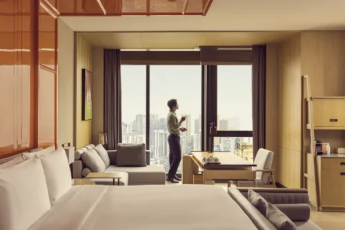 Still image of man enjoying skyline view from a stylish suite for Canopy by Hilton. By Photographer Toby Mitchell, represented by Pat Bates & Associates, a leading photography agency in the travel and hospitality brand sectors.